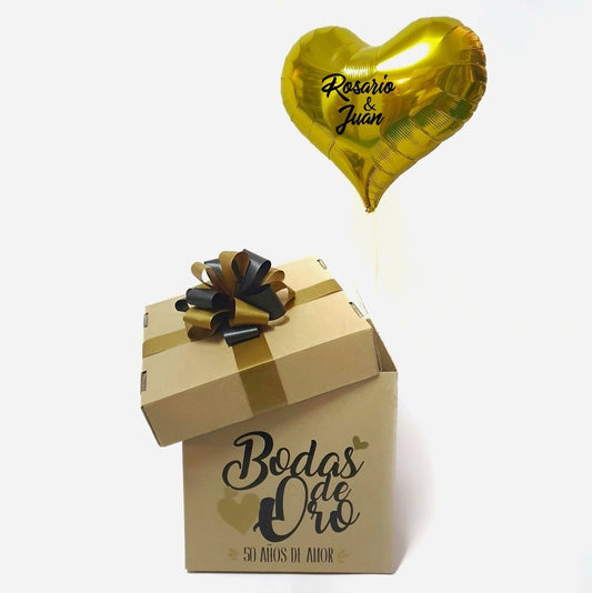 Regalo original para regalar en el aniversario de bodas de oro, al abrir la tapa de la caja saldrá un globo dorado con forma de corazón con una frase personalizada, podemos poner los nombres de la pareja u otra frase.